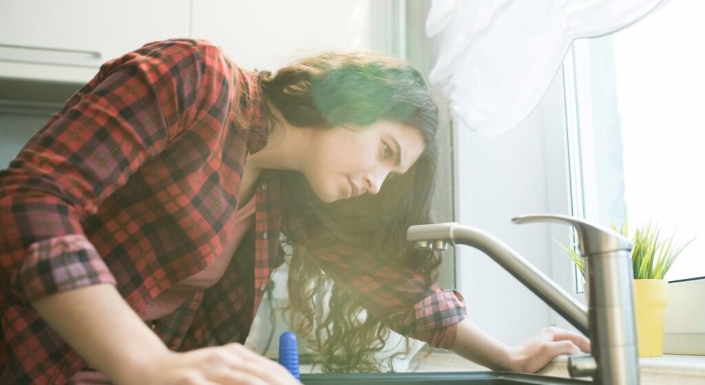 lady inspecting faucet